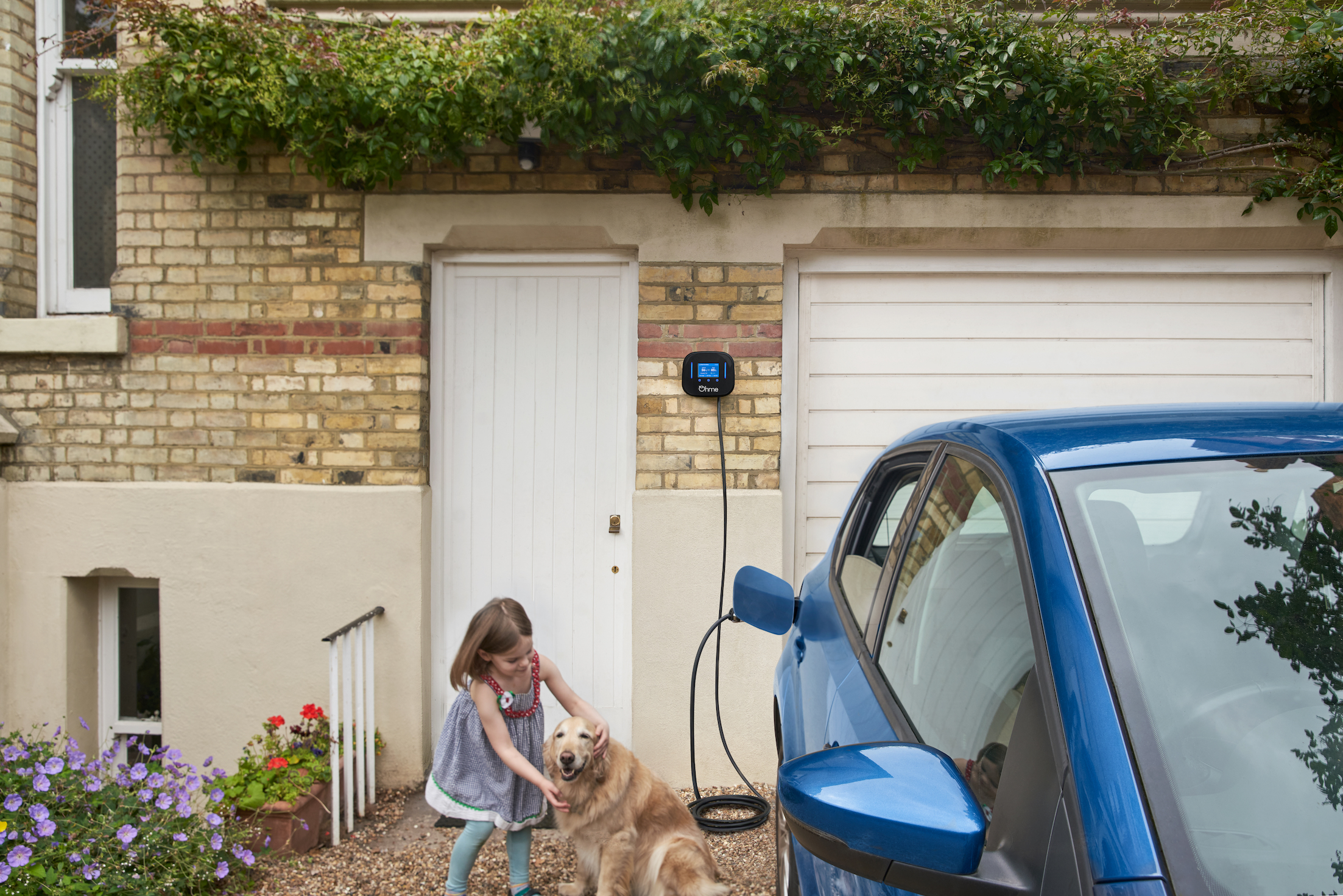 Ohme Home Pro EV charger, blue car, girl with dog