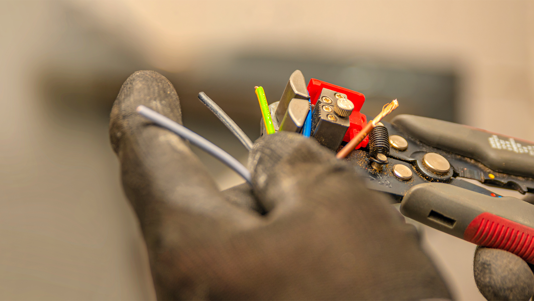 Hand holding electrical wires and wire cutters