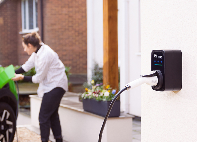 Ohme ePod with charger cable connected with a woman in the background