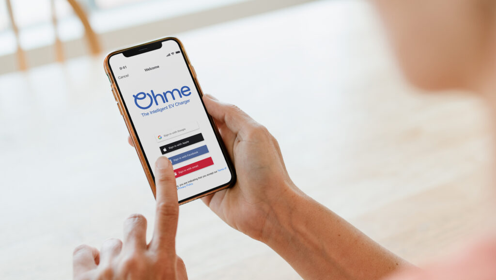 Person holding a mobile phone using the ohme app