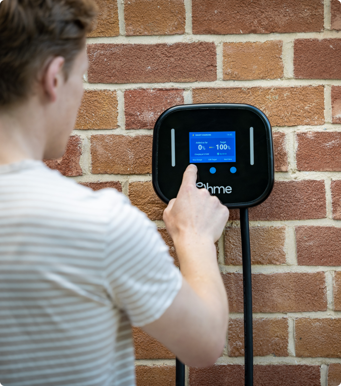 Man using Ohme Home Pro on a brick wall