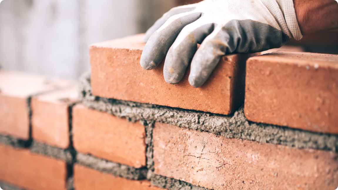 A hand building a brick wall