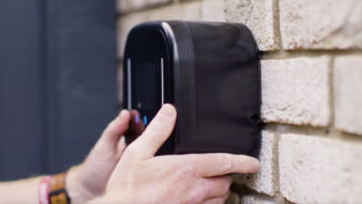 Ohme Home Pro EV Charger being mounted on a brick wall