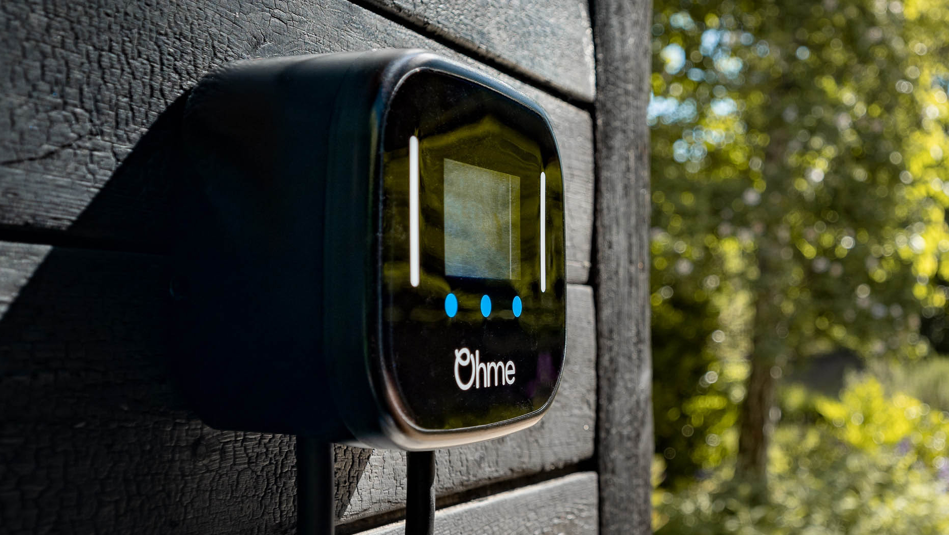 Ohme Home Pro EV charger on black wooden wall