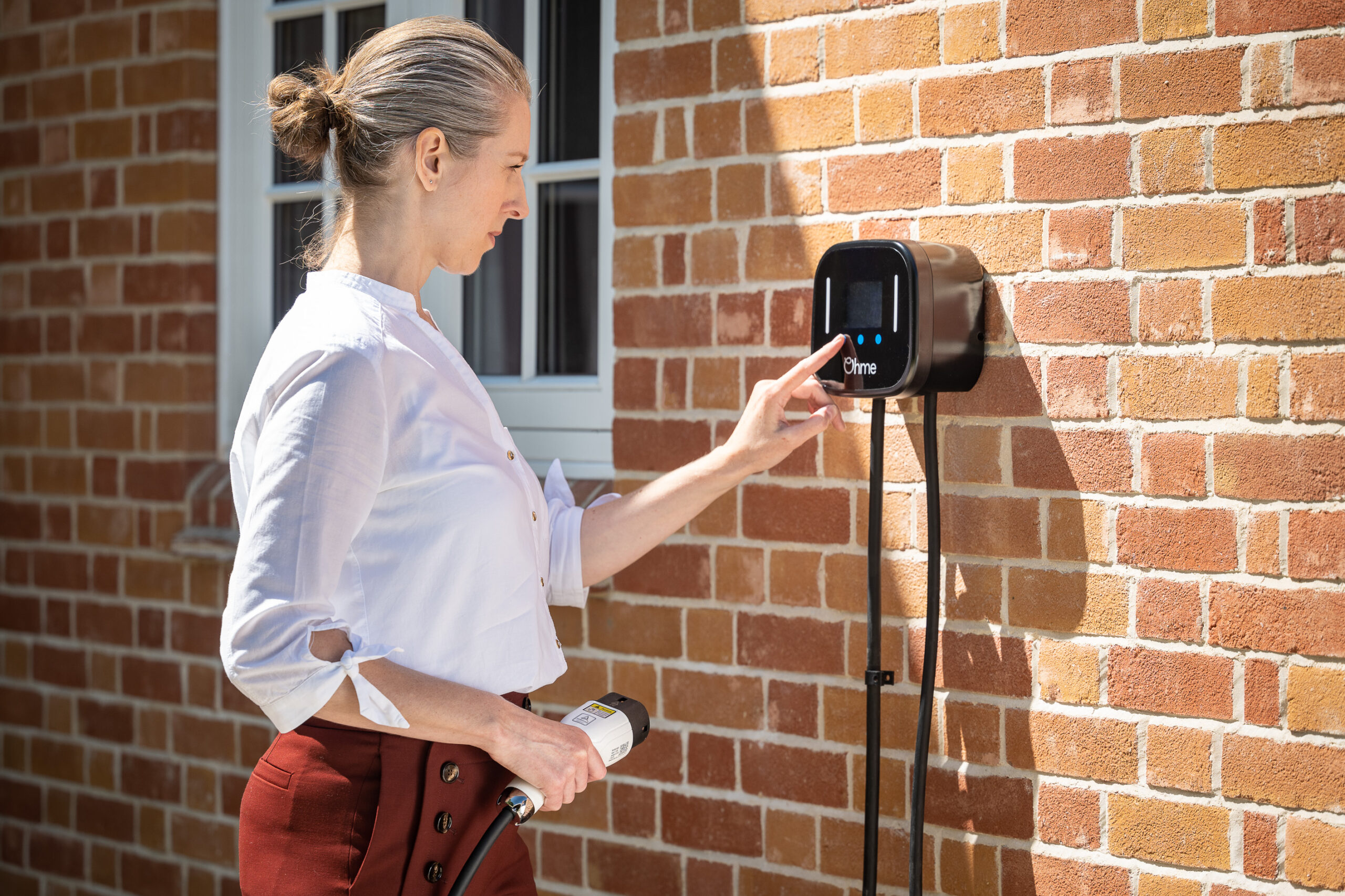 Lady operating Ohme Home Pro EV charger