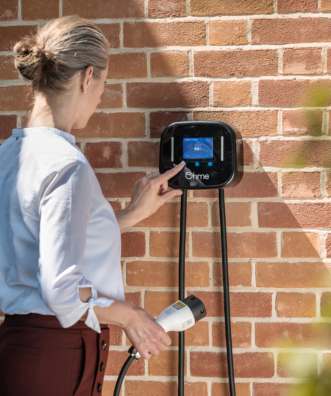 Woman using Ohme Home Pro EV charger