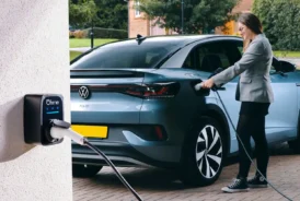 Lady plugging in blue VW ID4 electric car to home charger