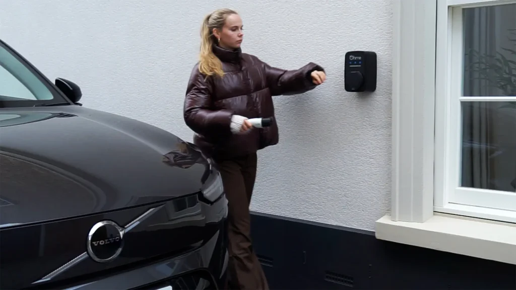 Lady plugging in Volvo EX90 to Ohme ePod home EV charger